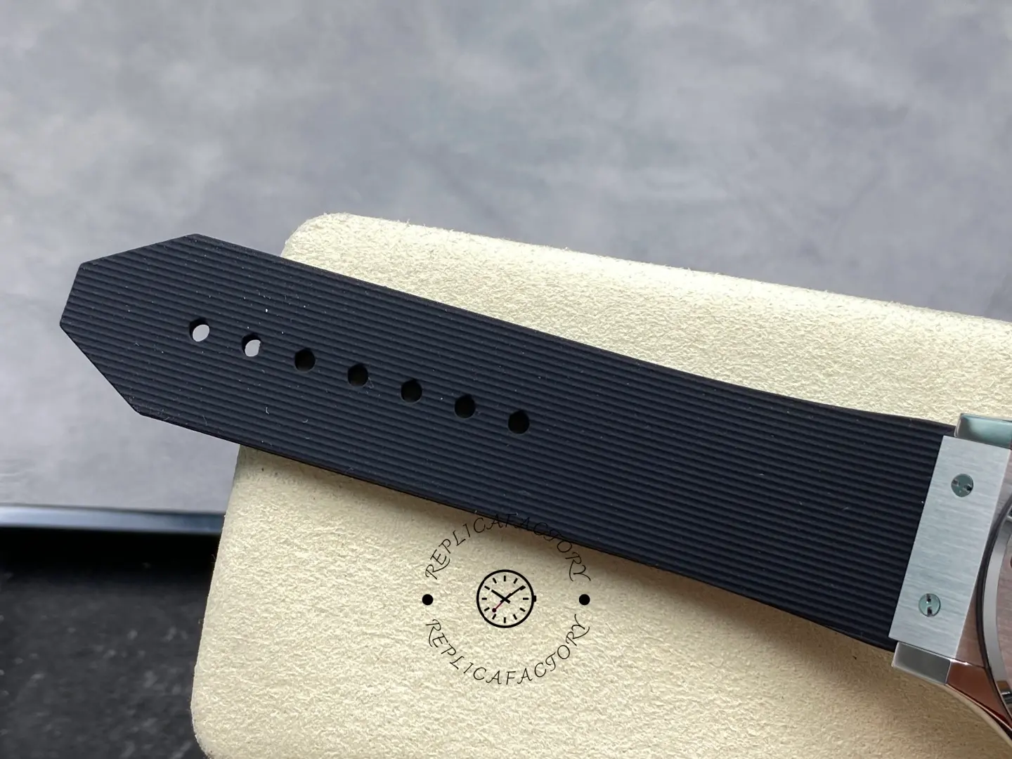 Rubber strap tail of Hublot 542.NX.1171.RX showing ribbed texture and sizing holes close-up.