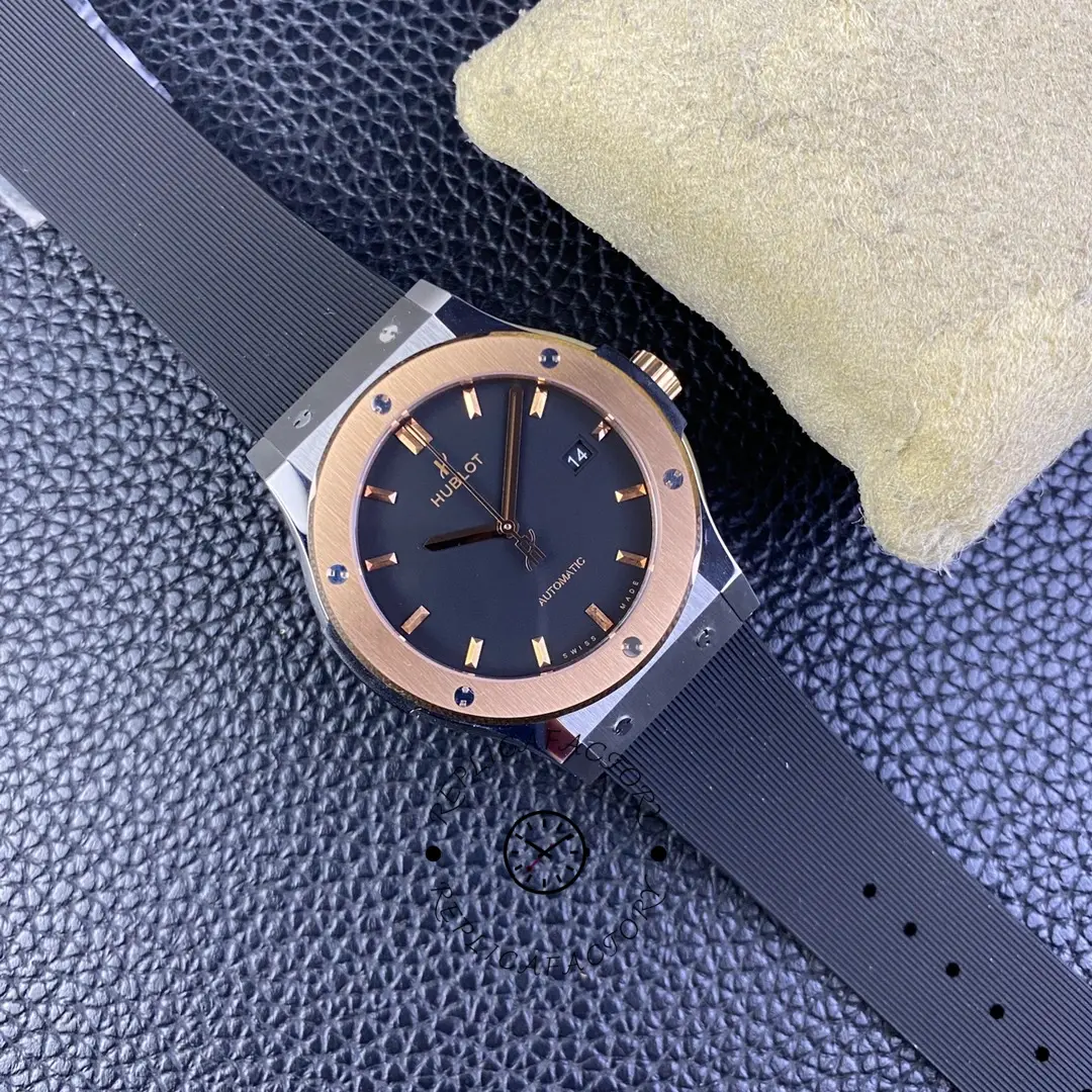 Side angle of Hublot Classic Fusion 511.CO.1181.RX, rose-gold bezel and black strap on cushion.