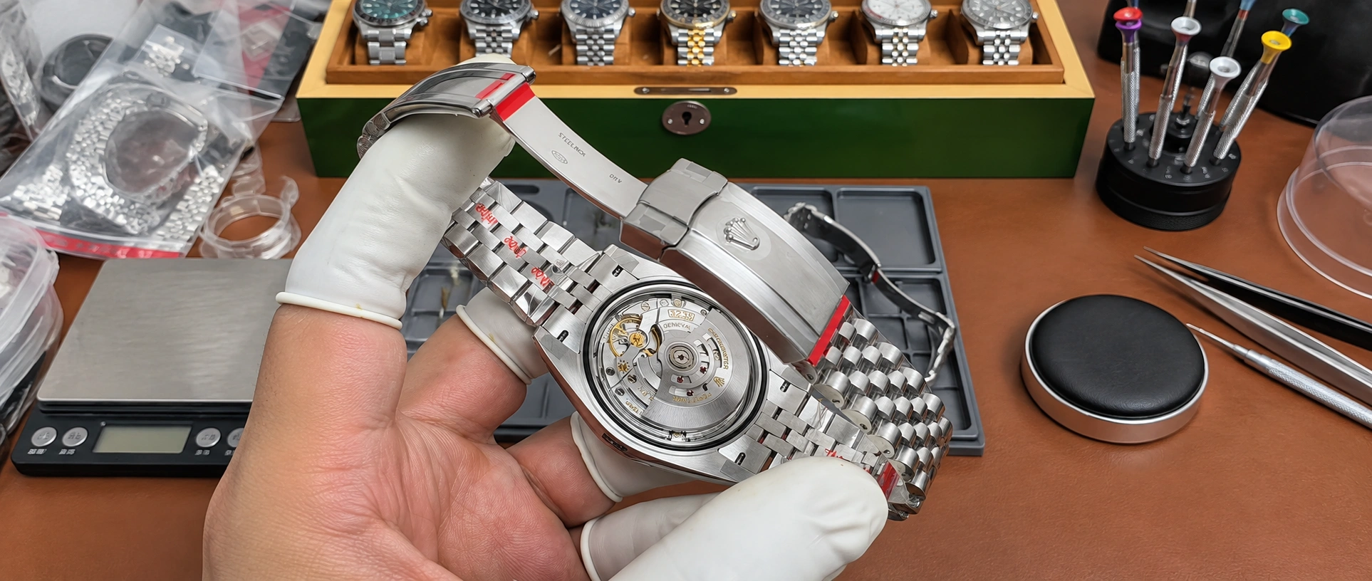 Mechanical watch movement and bracelet being inspected at a watchmaker's workbench