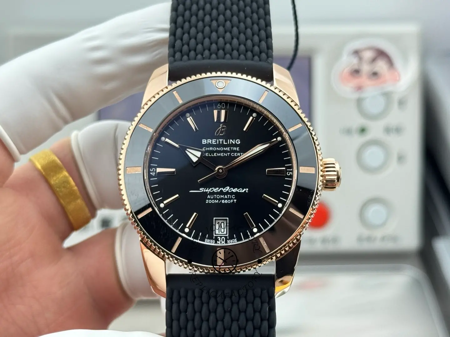 Breitling RB2010121B1S1, front view in hand with black dial and rose-gold bezel, 42mm replica.