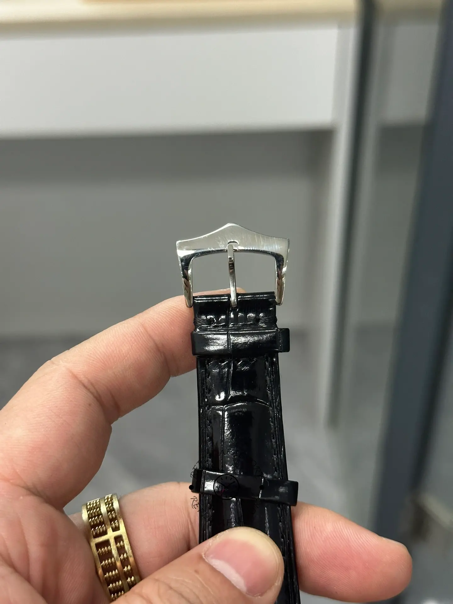 Strap buckle detail of Patek Philippe Calatrava 5196G-001 showing clasp end and leather texture.