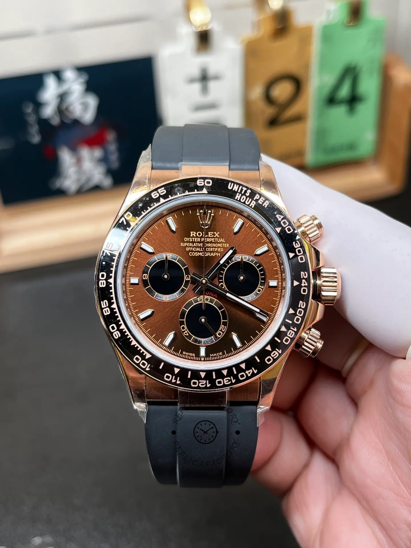Front hand-held view of Rolex 126515LN-0010 Daytona with brown dial, black subdials and black Oysterflex strap.