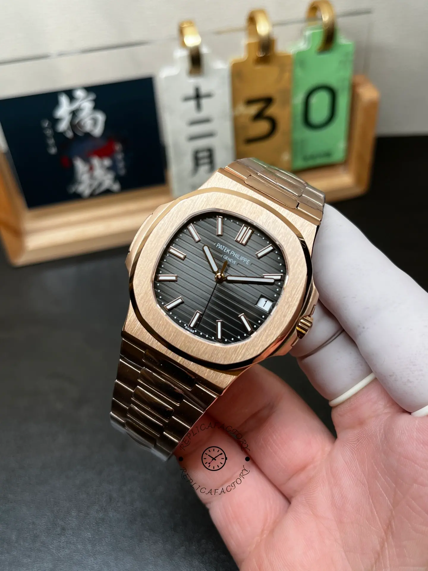 Hand-held angled view of Patek Philippe Nautilus 5711/1R-001 highlighting brown dial texture and bezel shape.