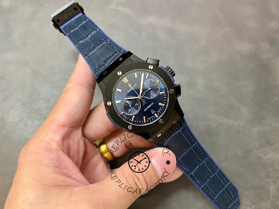 Wrist-scale shot of Hublot 521.CM.7170.LR held in hand, showing full watch with blue strap.