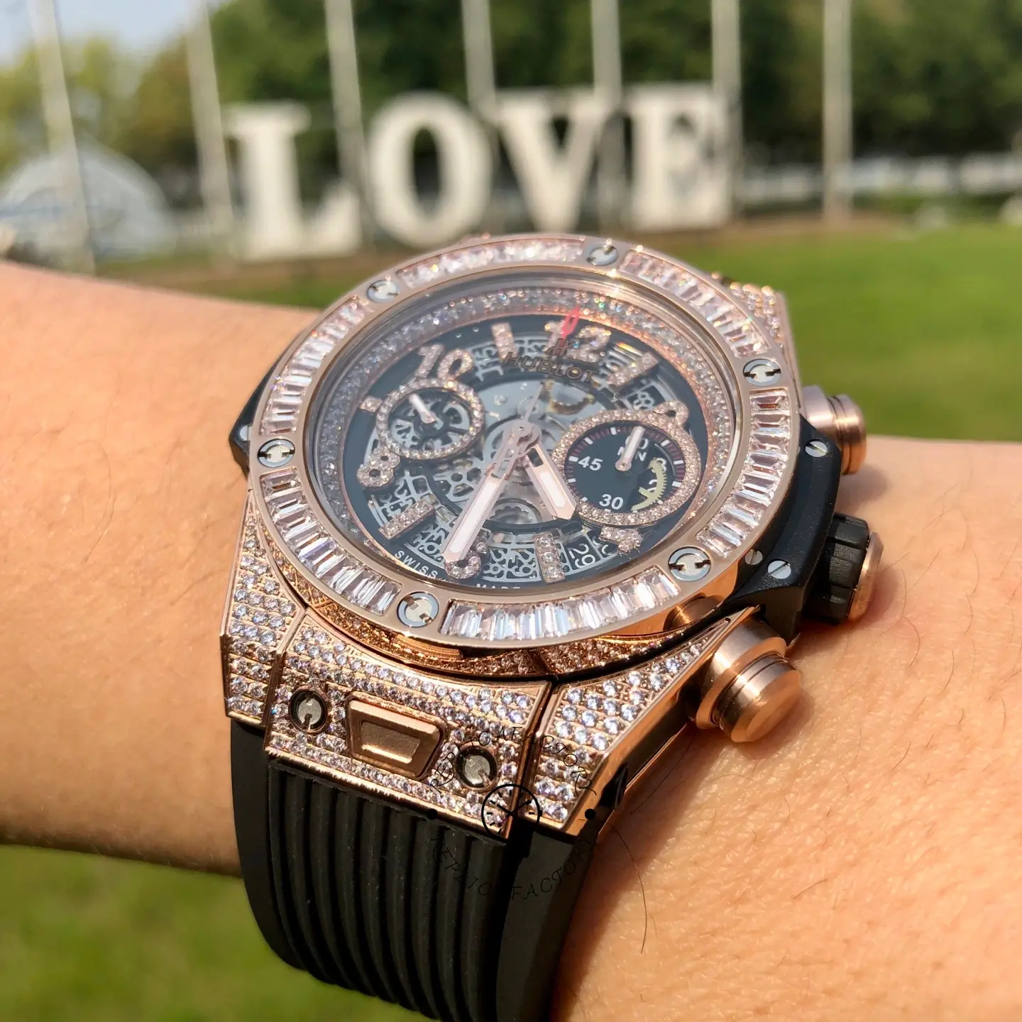 Angled wrist close-up of Hublot 421.OX.1180.RX.0904 emphasizing bezel stones, pushers, and case finishing.