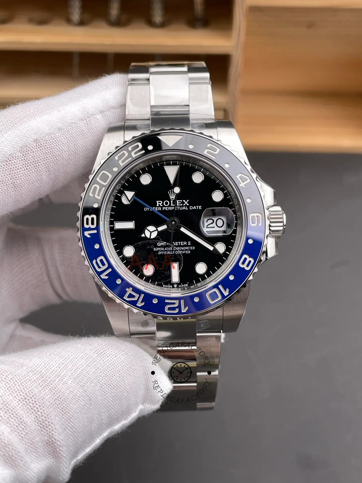 Front view of Rolex GMT-Master II 116710BLNR with black dial, blue-black bezel, and Oyster bracelet in gloved hand.