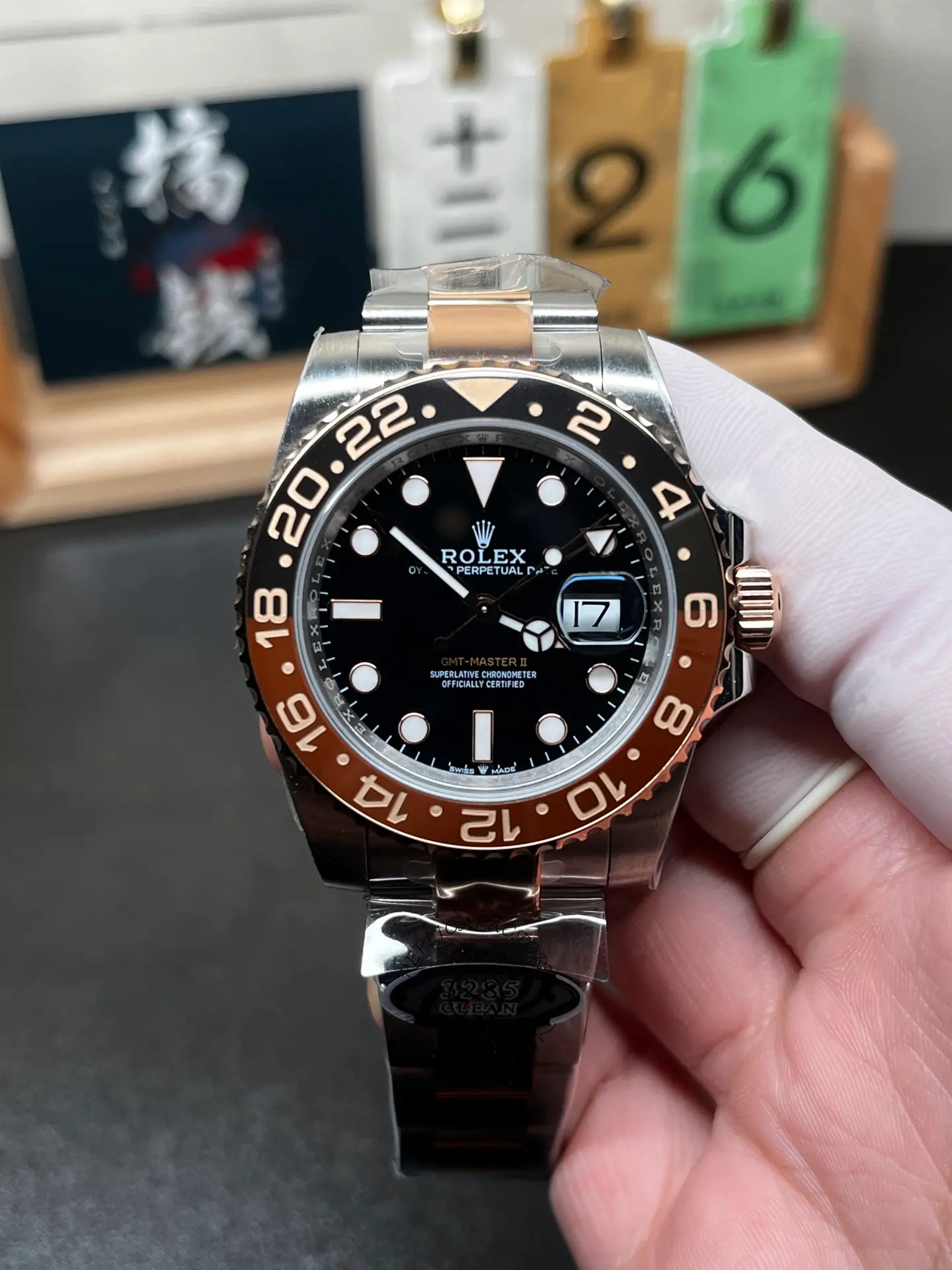 Front hand-held view of Rolex 126711CHNR GMT-Master II with black dial and black brown bezel.