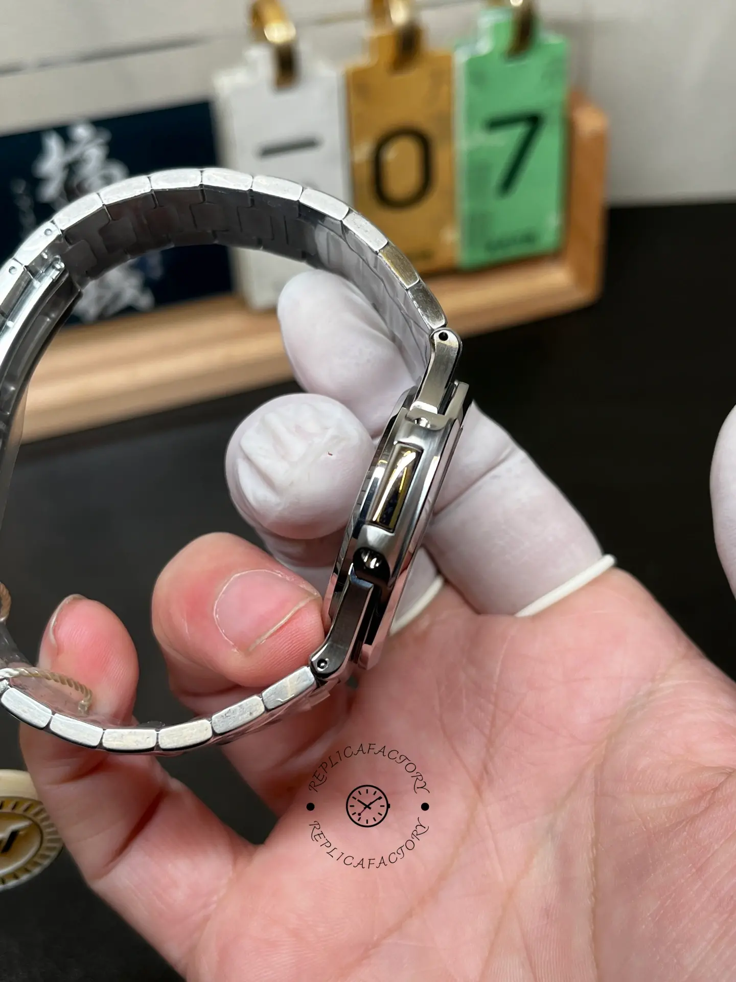 Hand-held side angle of Patek Philippe Nautilus 5711/1A showing bracelet fit and case edge.