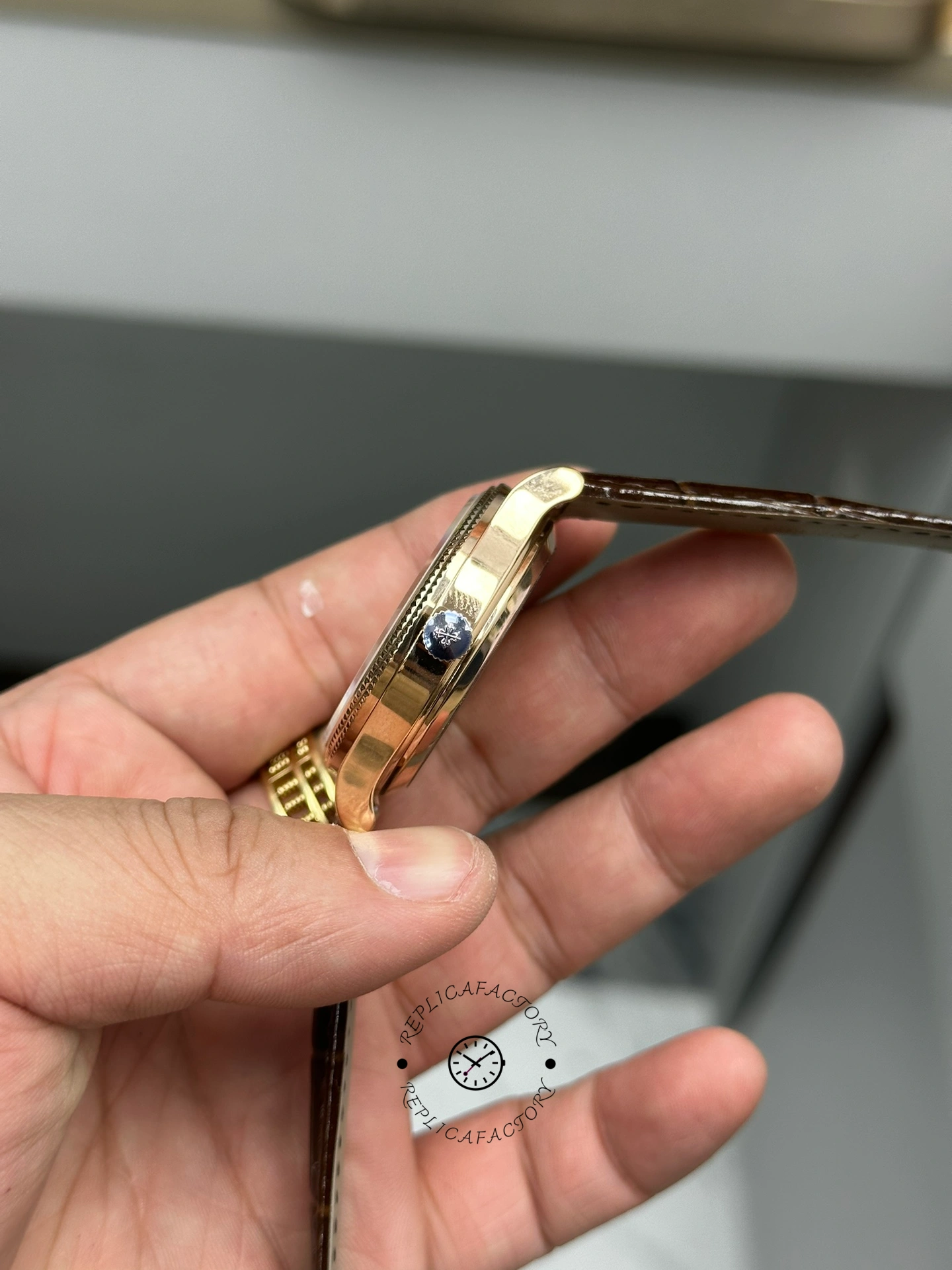 Side view in hand of Patek Philippe Calatrava 6119R-001 showing case thickness and crown.