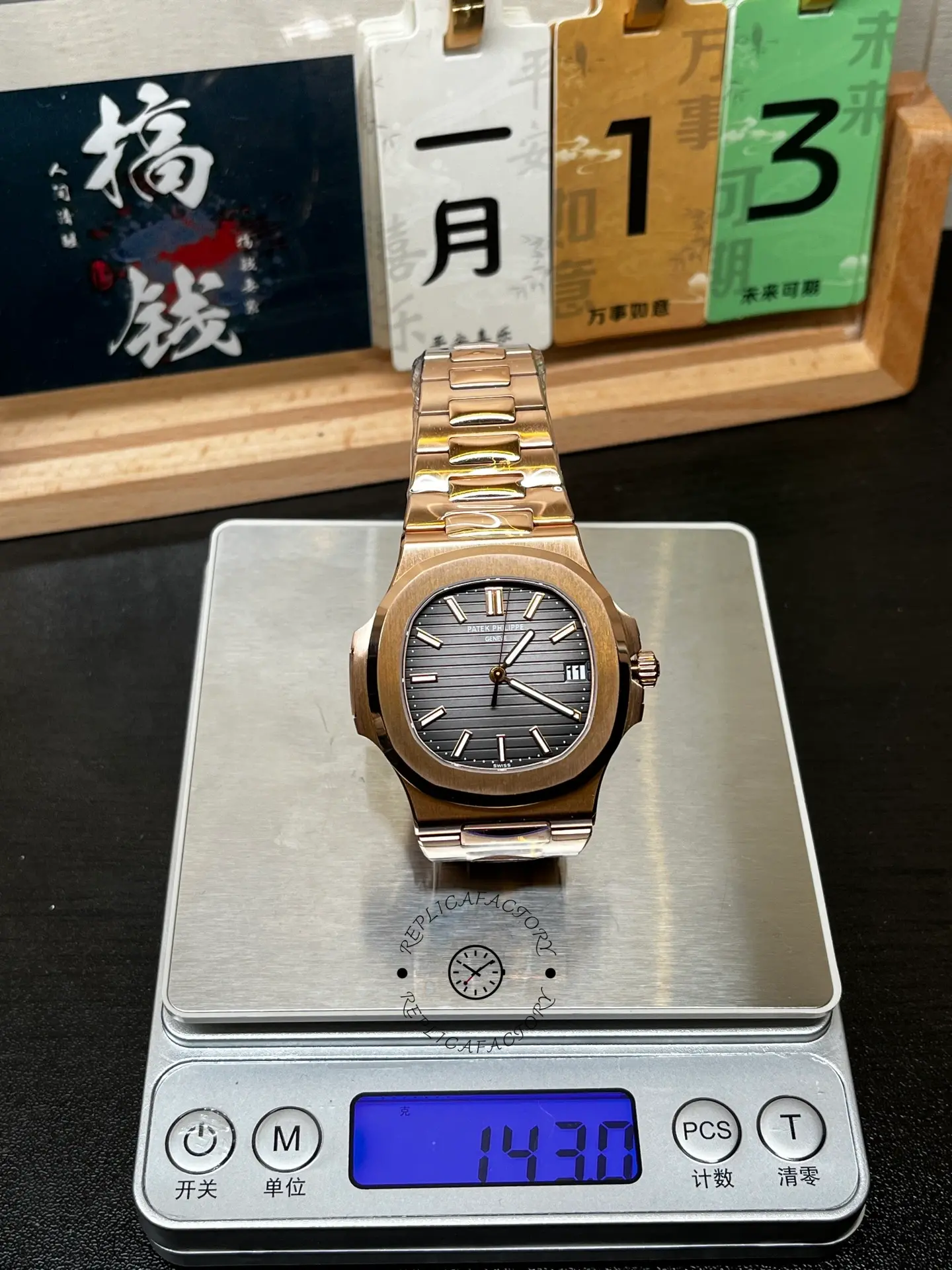 5711 1R 001 rose gold Nautilus on a scale, showing the black dial and bracelet weight display.