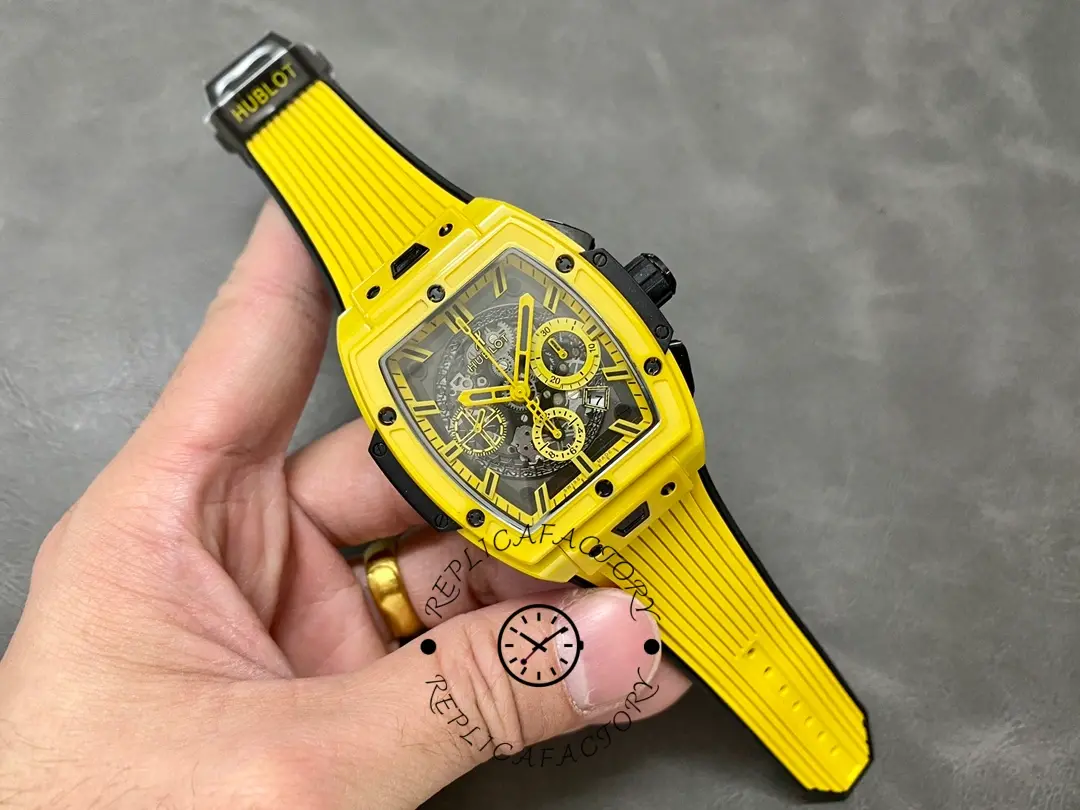 Hand view of Hublot 642.CY.011Y.RX emphasizing yellow strap fit and tonneau shape.