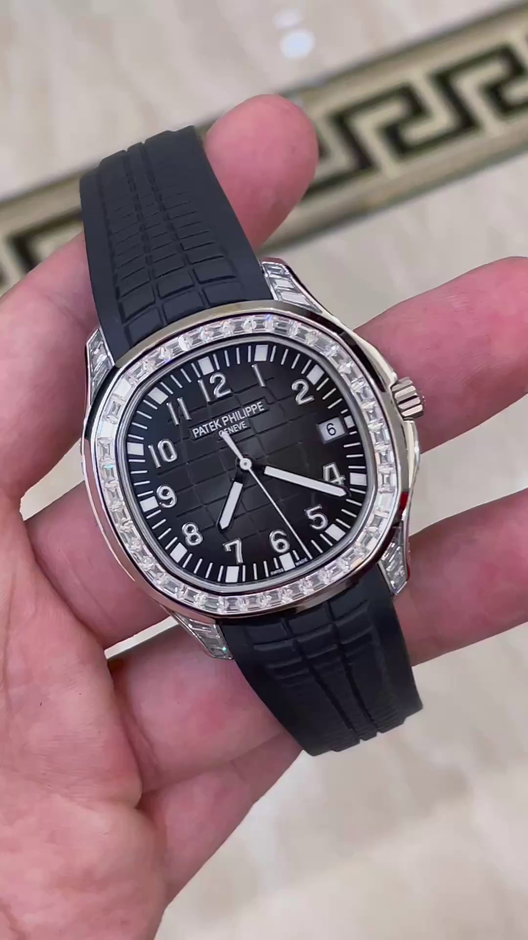 Video: hand-held Patek Philippe Aquanaut 5167/300G-010 showing black dial and strap texture. - Video