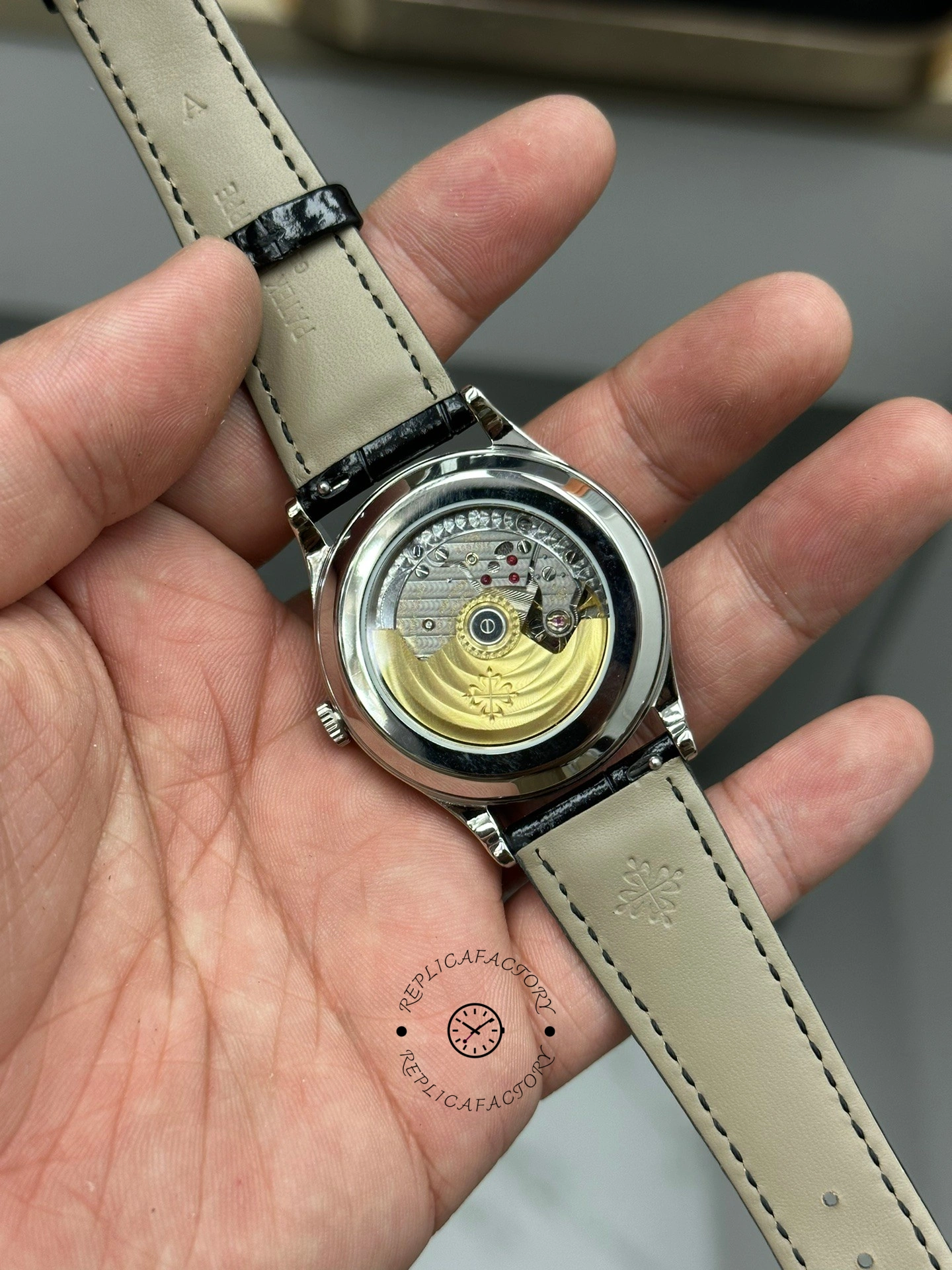 Caseback angle of Patek Philippe Calatrava 6119G-001 showing gold rotor and beige strap attachment.
