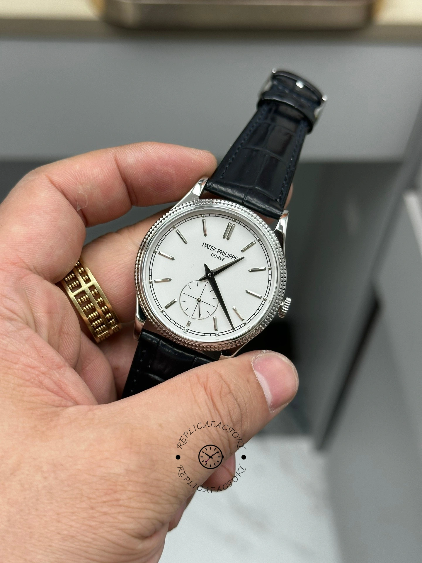 Hand-held front angle of Patek Philippe Calatrava 6119G-001 white dial showing bezel and lugs.