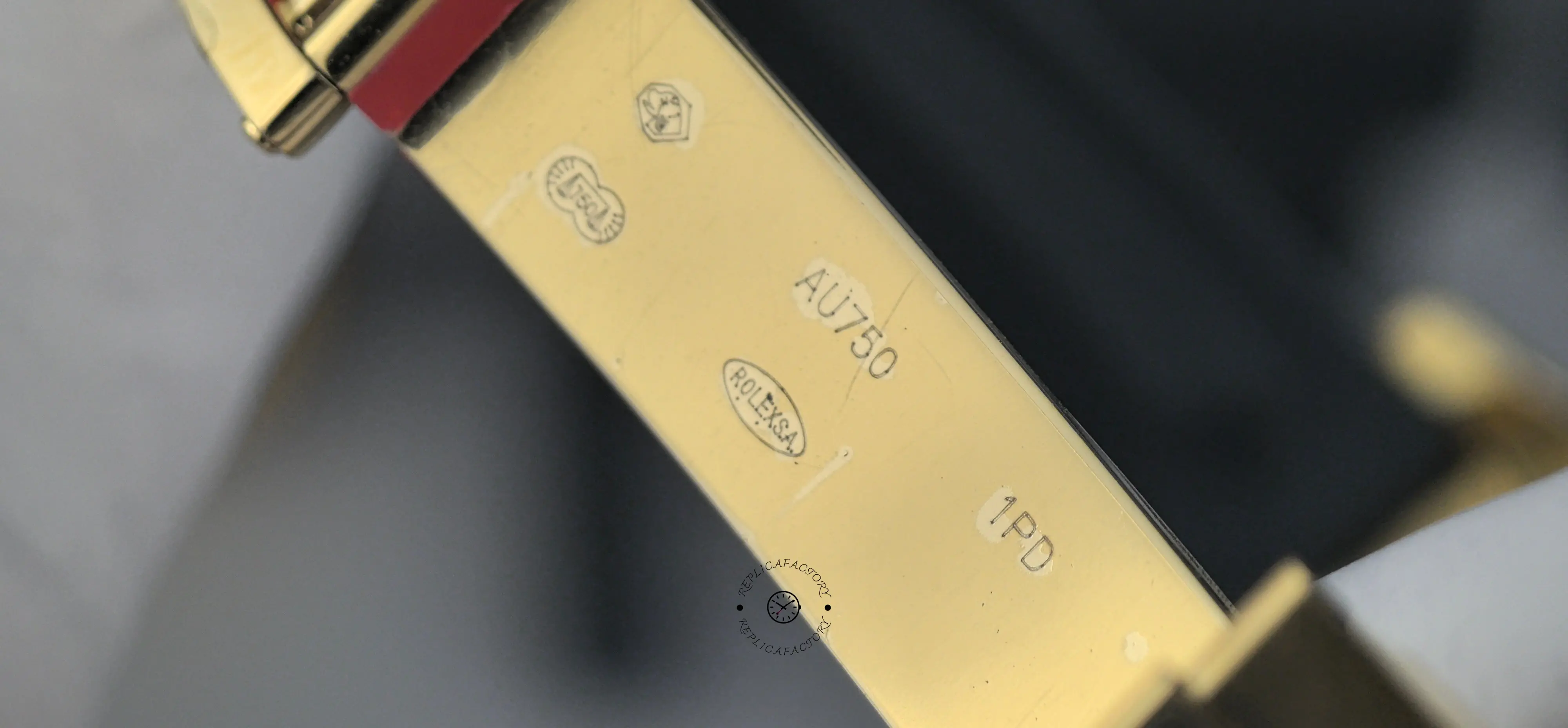 Close-up of Rolex Daytona 116518LN clasp interior showing markings on gold-tone metal surface.