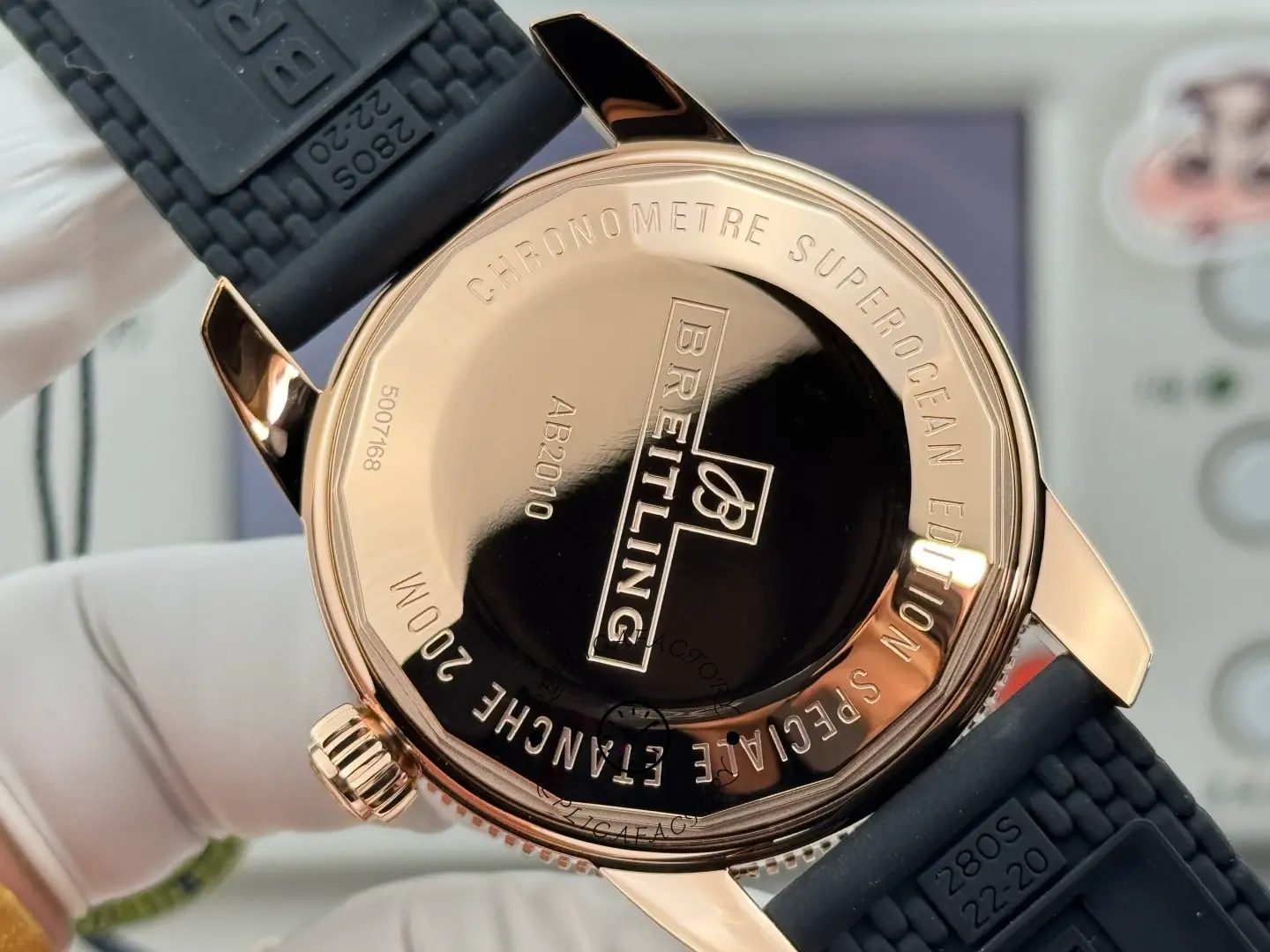 Breitling RB2010121B1S1, caseback view with protective sticker and engraved markings.