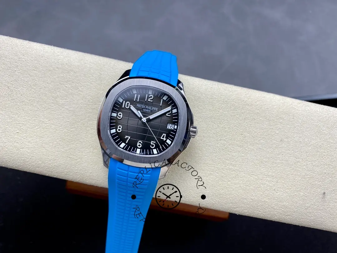 Watch on cushion: Patek Philippe Aquanaut 5167A-001 showing dial layout and blue strap.