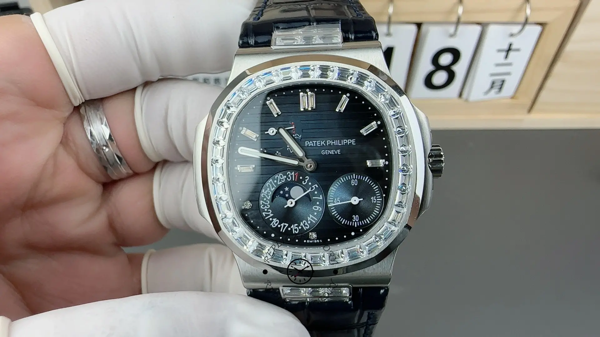 Hand-held close-up of Patek Philippe Nautilus 5724G-001 showing moonphase subdial and applied indices.