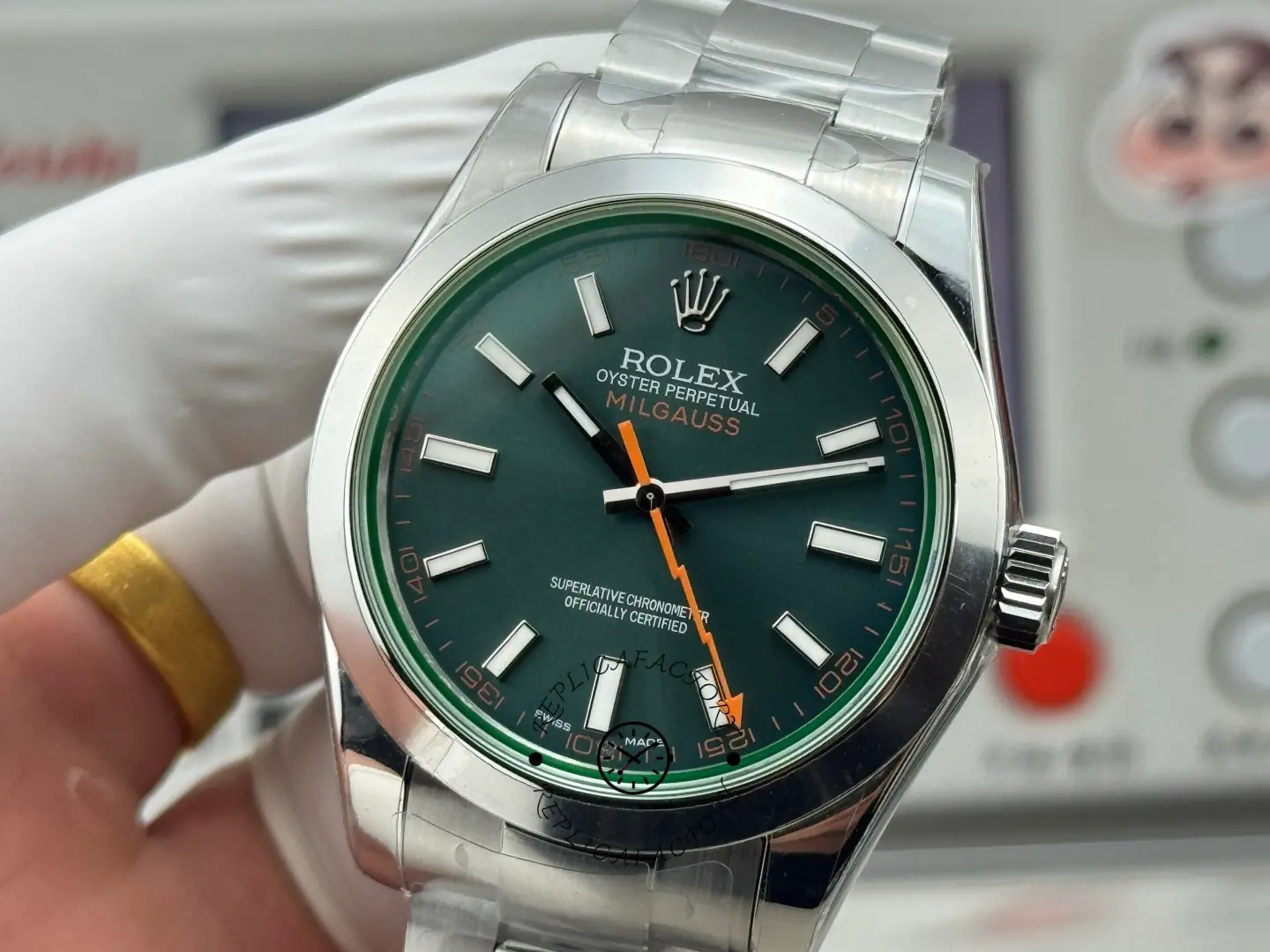Close-up angled view of Rolex Milgauss 116400GV-0002 dial with green crystal effect and orange hand.