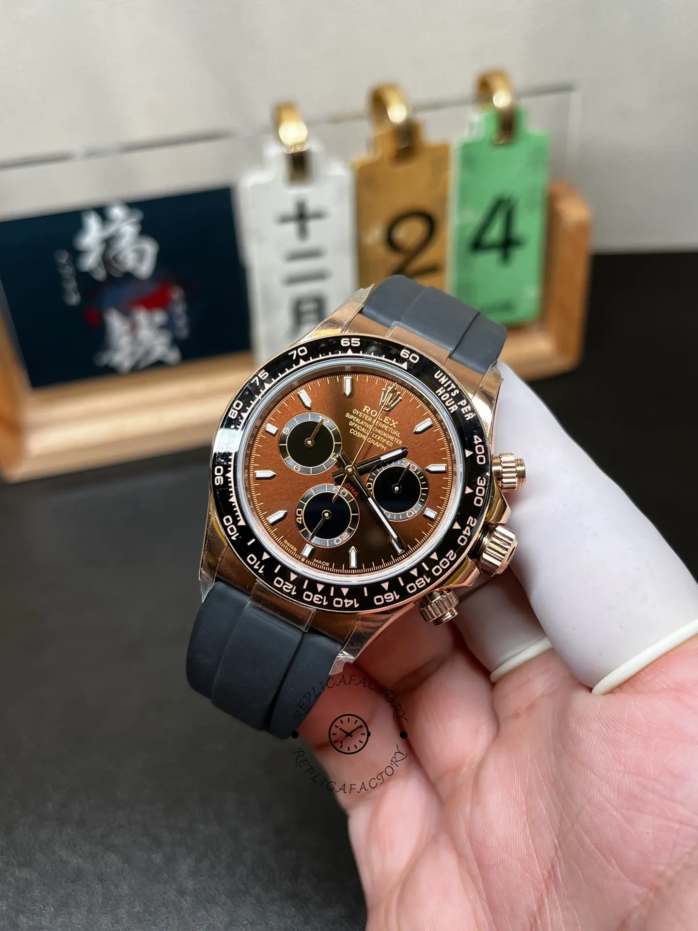 Angled hand-held front view of Rolex 126515LN-0010 Daytona with brown sunburst dial and black ceramic bezel.