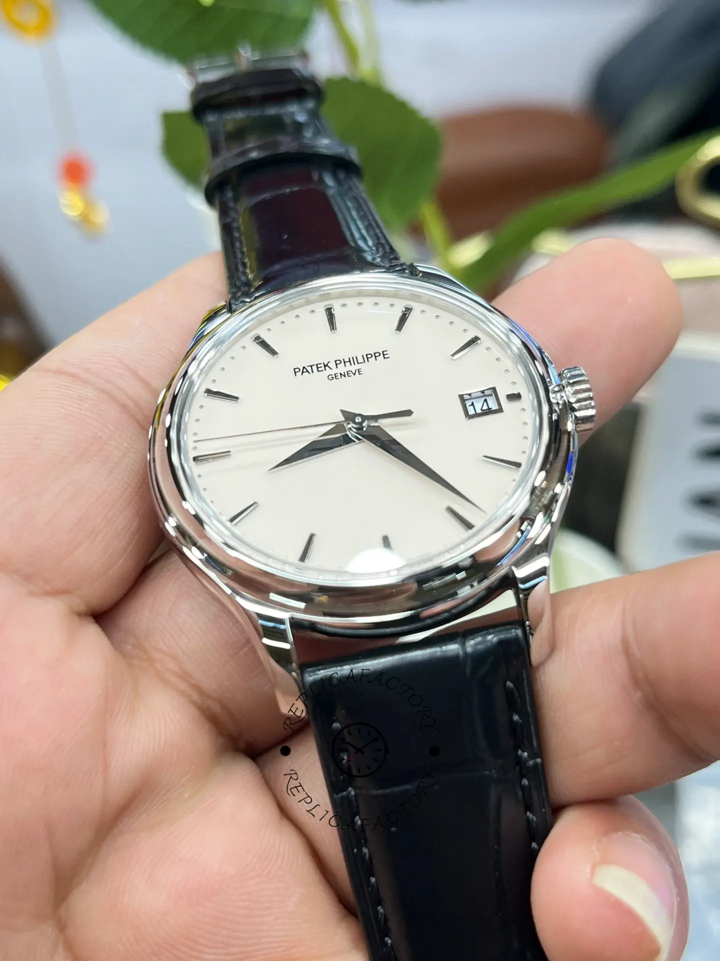 Hand-held dial view of the Patek Philippe Calatrava 5227G-001 with sharp printing and clean finish.