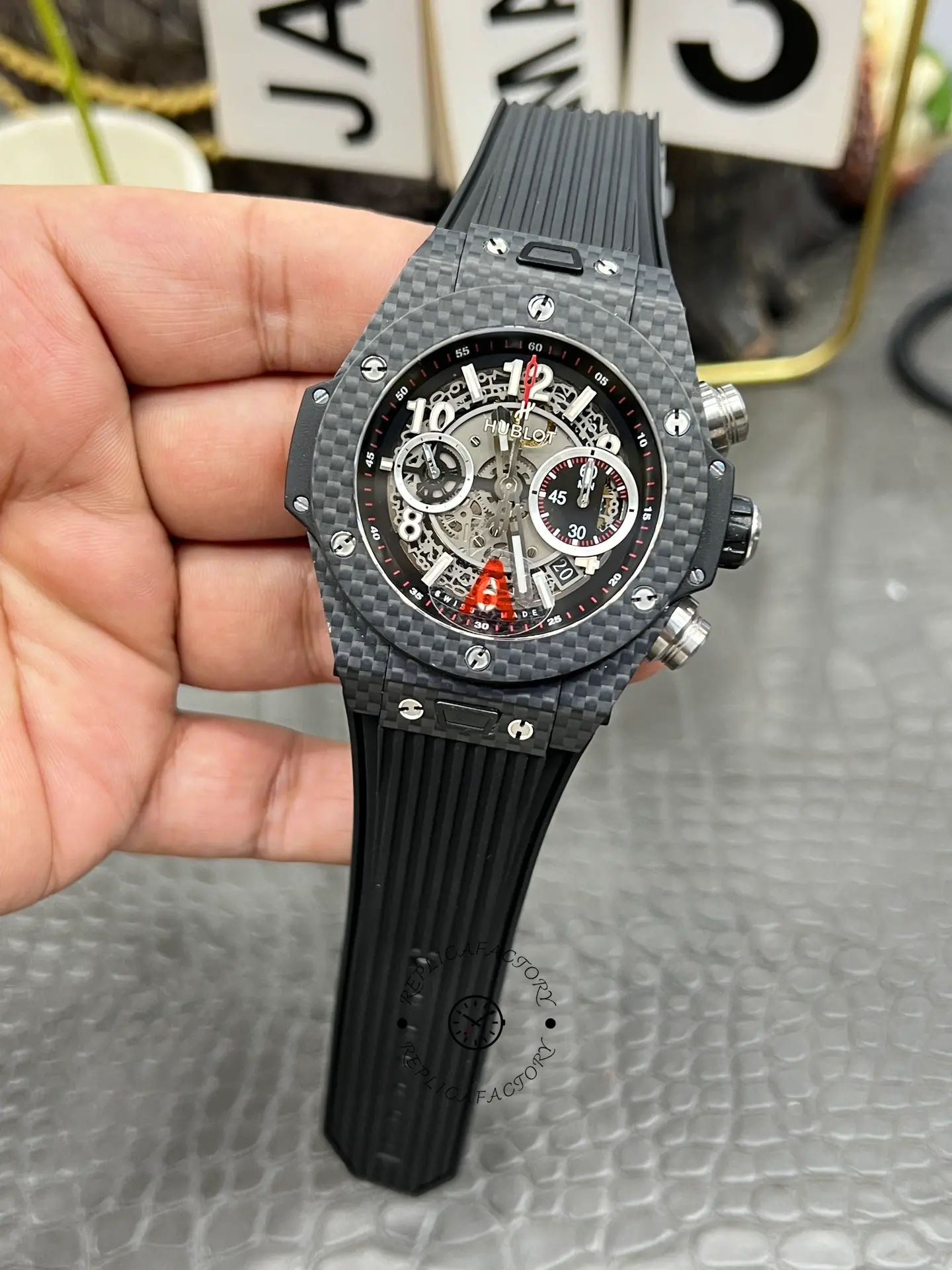 Hublot Big Bang UNICO 411.QX.1170.RX hand-held full view, black rubber strap and carbon case.