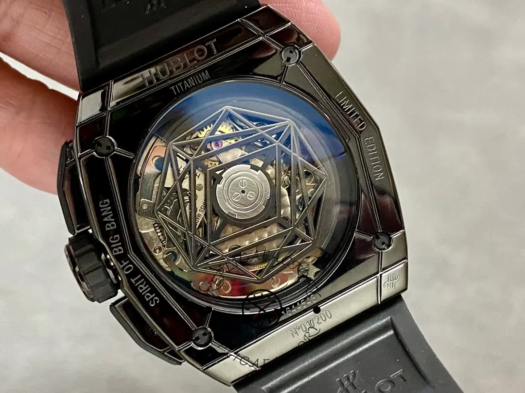 Caseback view of Hublot 648.CX.0114.RX.MXM23 showing exhibition back, rotor, and engraved caseback text.
