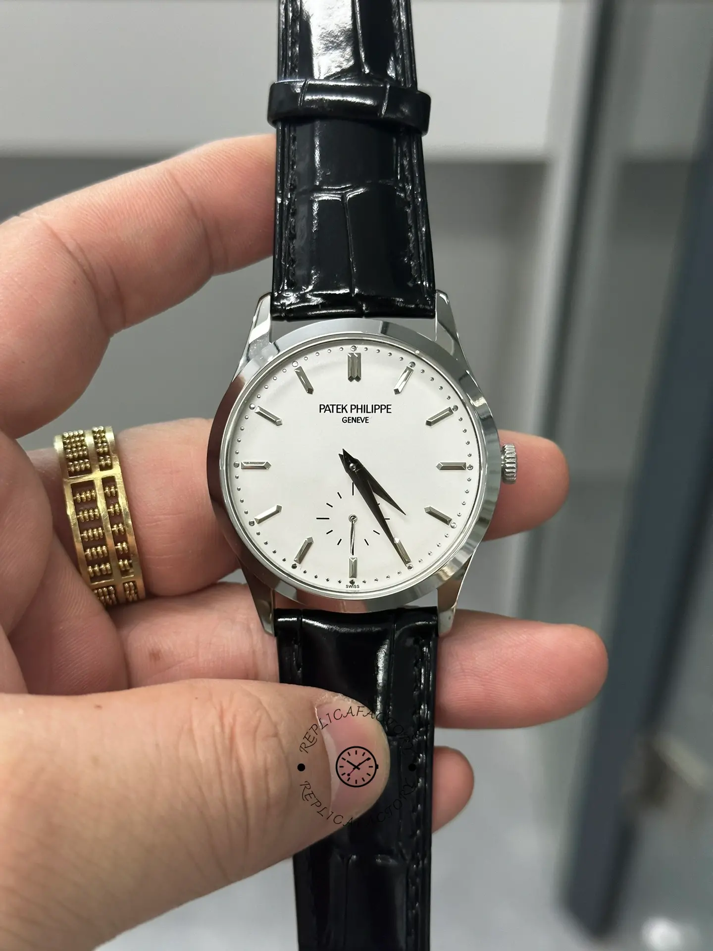 Hand-held close-up of Patek Philippe Calatrava 5196G-001 showing clean markers and polished white-gold case.
