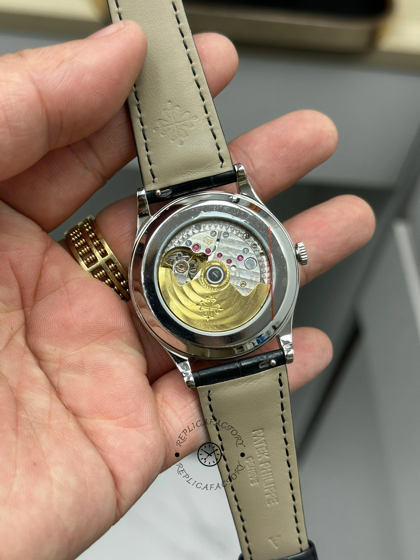 Caseback view of Patek Philippe Calatrava 6119G-001 showing movement through sapphire back in hand.