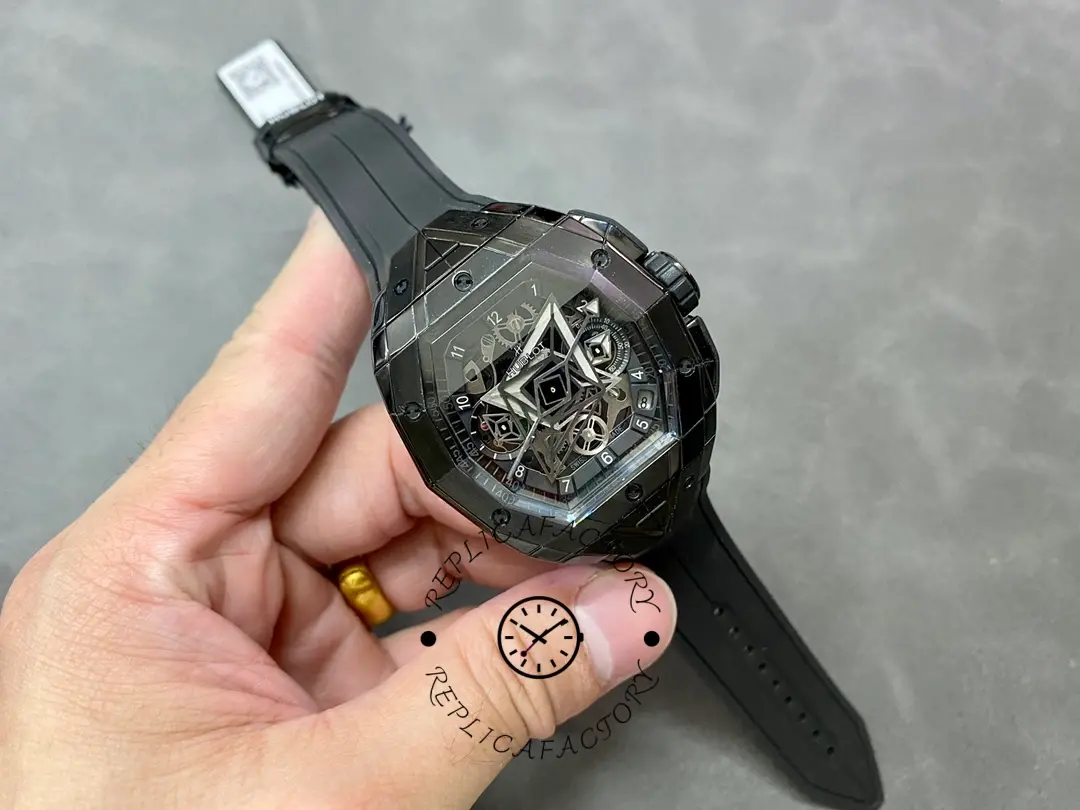 Full watch in hand of Hublot 648.CX.0114.RX.MXM23 showing overall tonneau shape and rubber strap length.