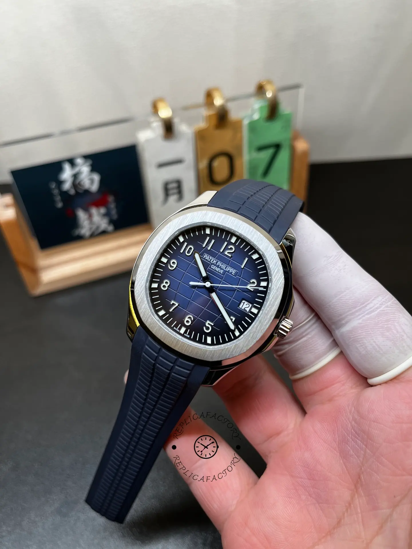 Hand-held angled view of Patek Philippe Aquanaut 5168G-001 highlighting dial layout and bezel shine.