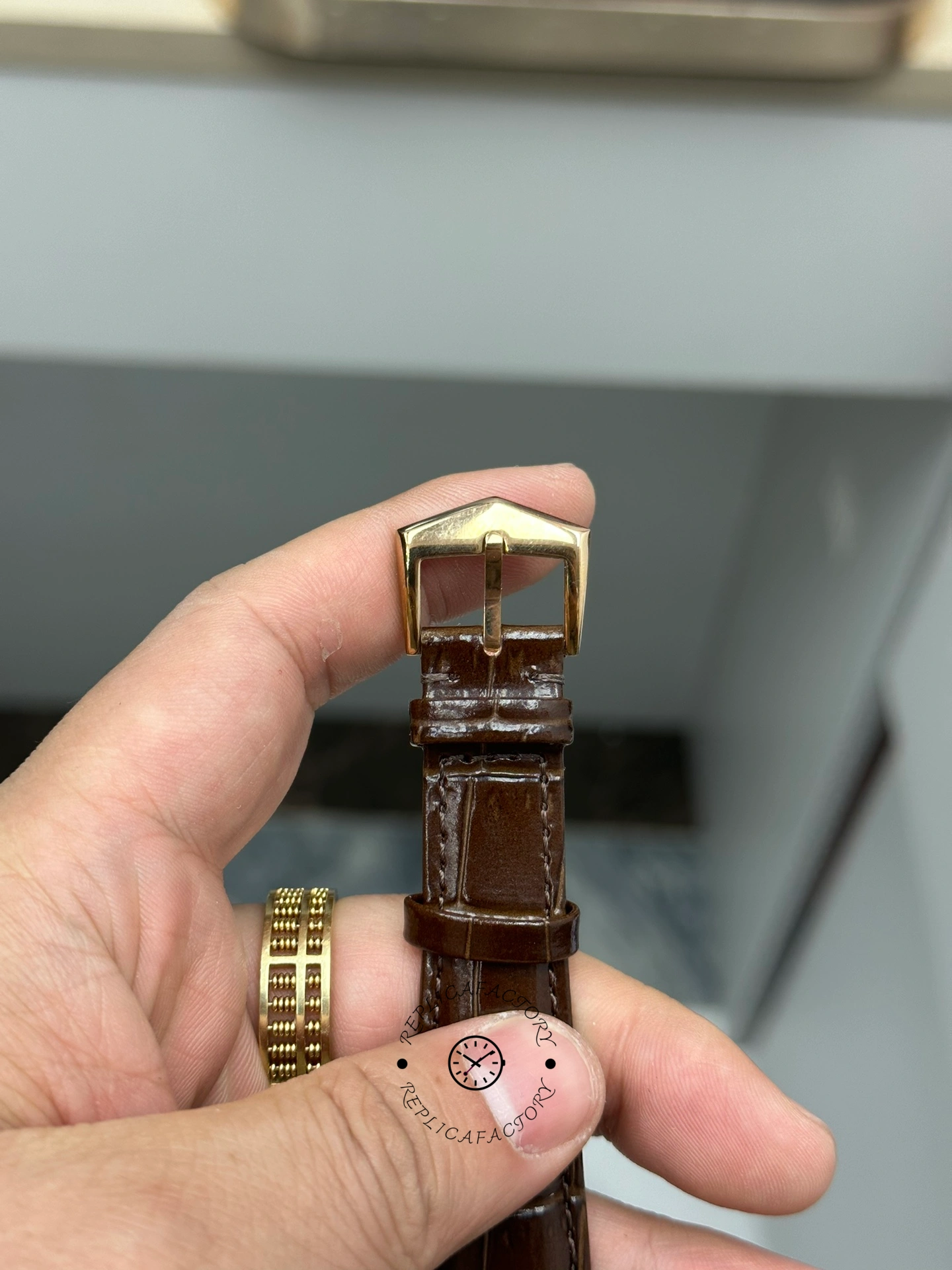 Wrist-style shot of Patek Philippe Calatrava 6119R-001 showing brown strap and clasp.