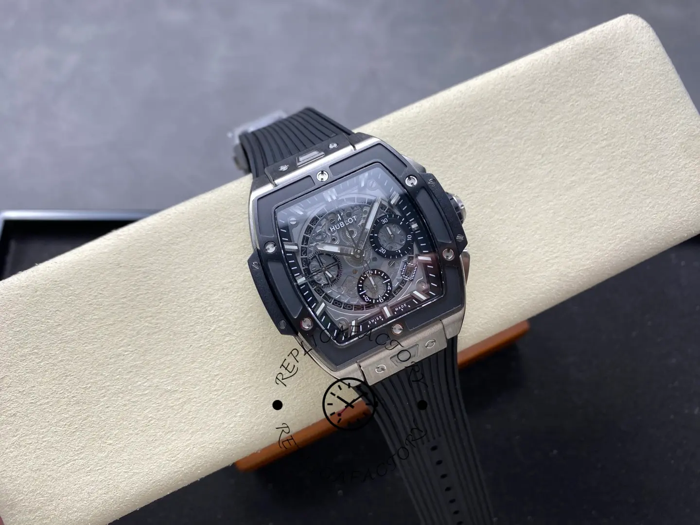 Full watch shot of Hublot 642.NM.0170.RX on display cushion with tonneau case and rubber strap.