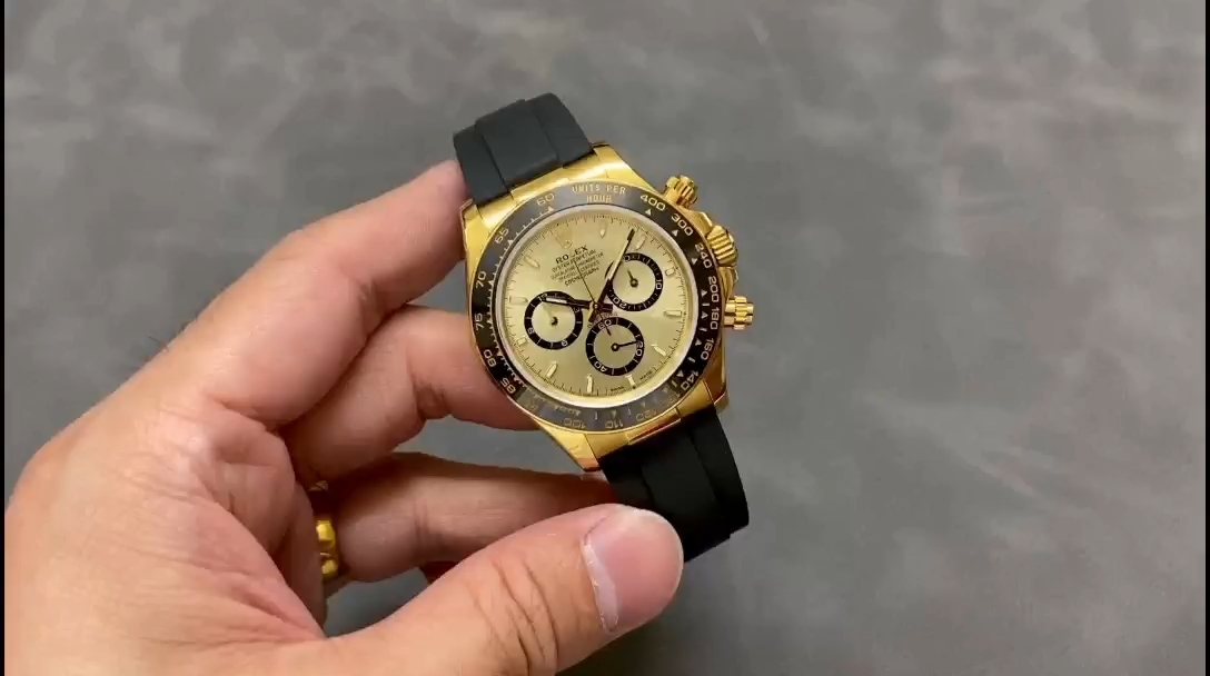 Video: hand holding Rolex Daytona 126518LN-0010, gold case and champagne dial visible. - Video