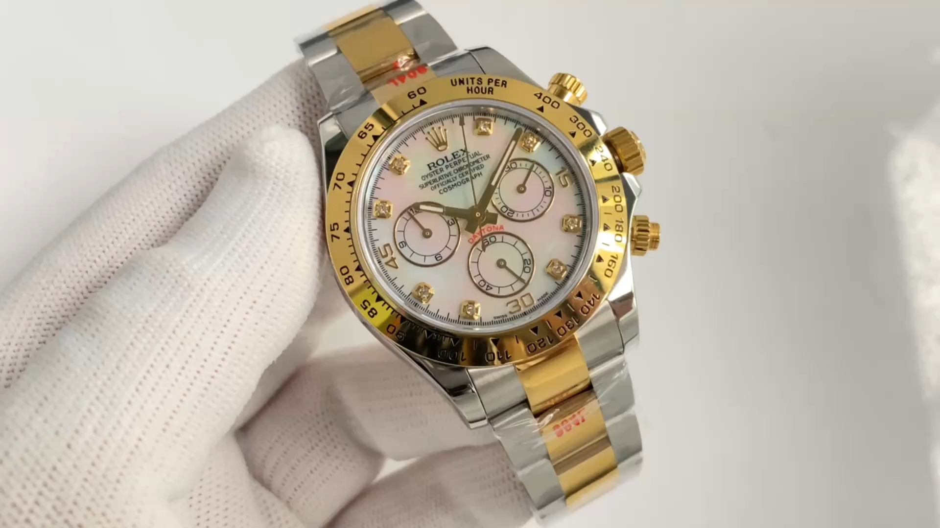 Video: gloved hand holding Rolex Daytona 116523, diamond MOP dial visible. - Video
