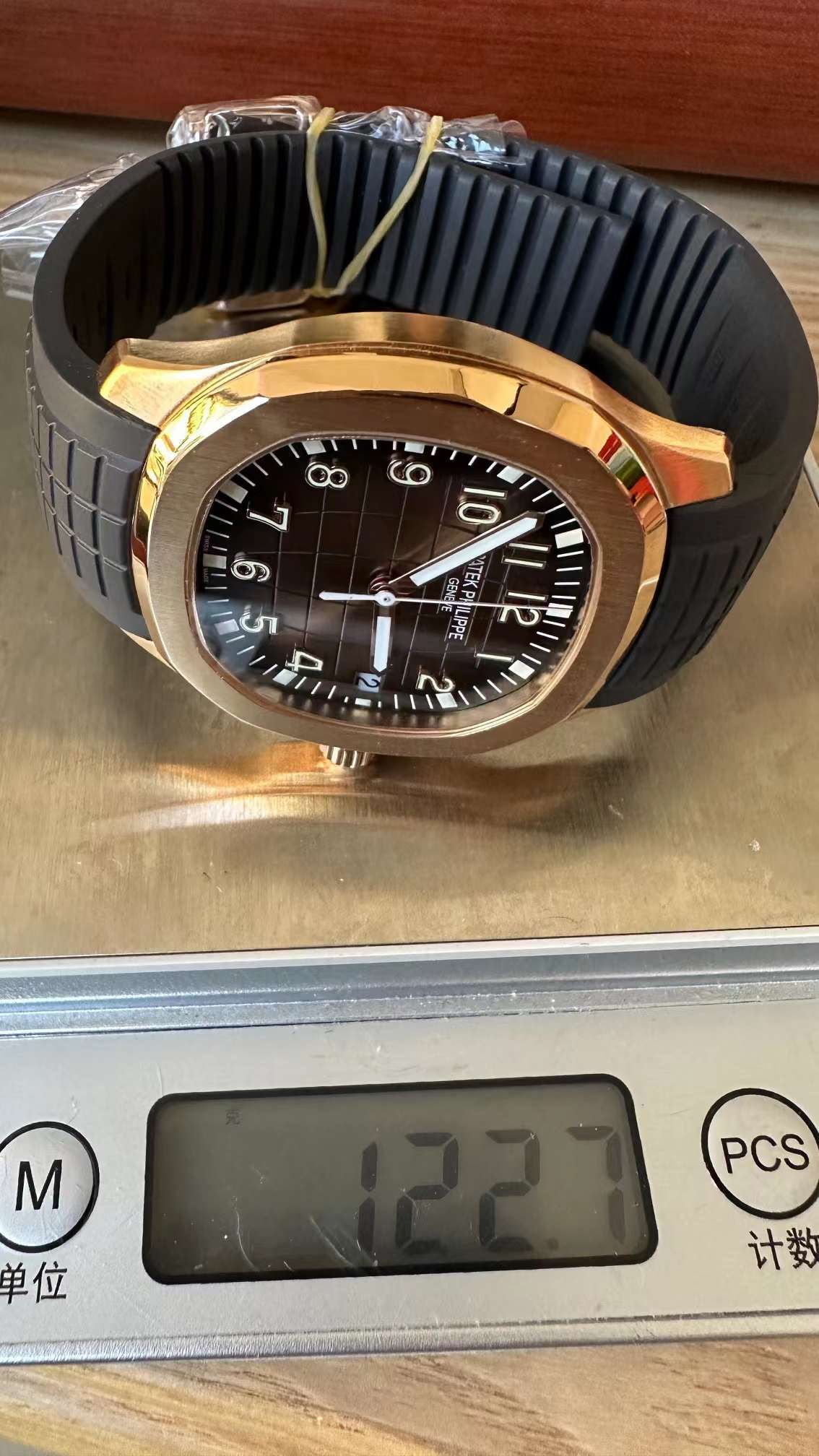 Weighing shot of Patek Philippe Aquanaut 5167R-001 on scale showing watch weight with strap.