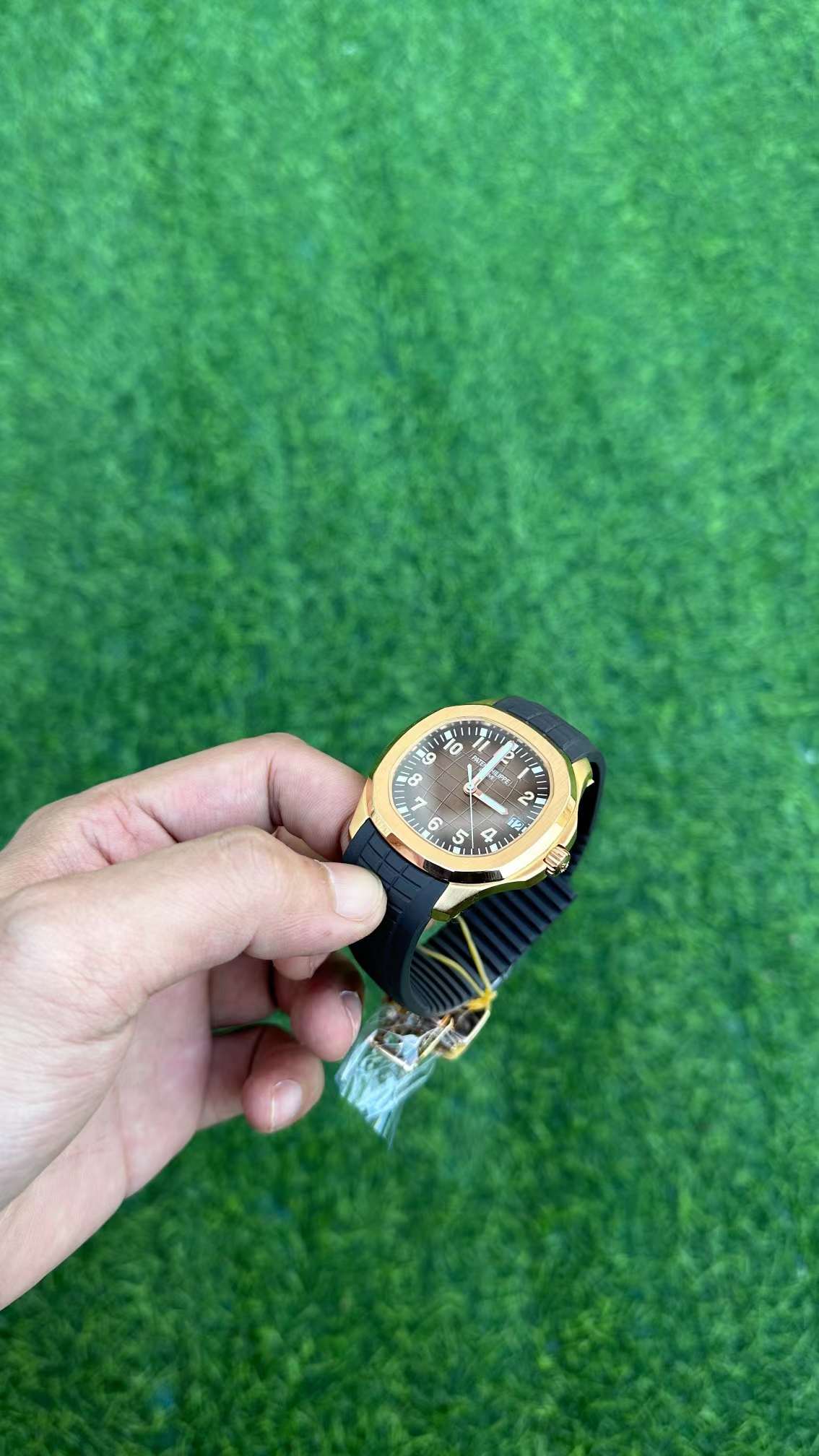 Side angle in hand of Patek Philippe Aquanaut 5167R-001 showing crown side and strap fit.