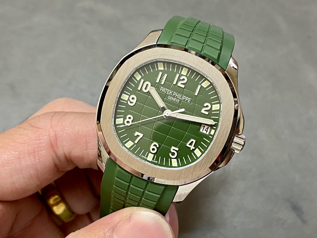 Hand-held view of Patek Philippe Aquanaut 5168G-010 showing green strap fit and case size.