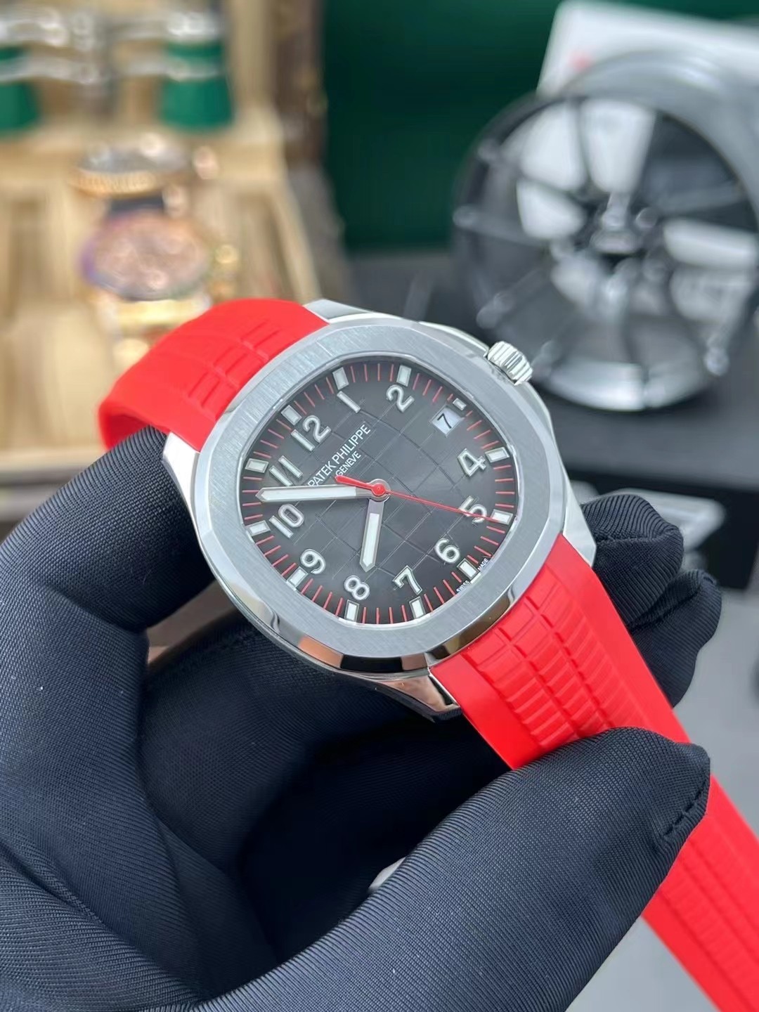 Angled hand-held shot of Patek Philippe Aquanaut 5167A-012 showing dial texture and polished bezel.