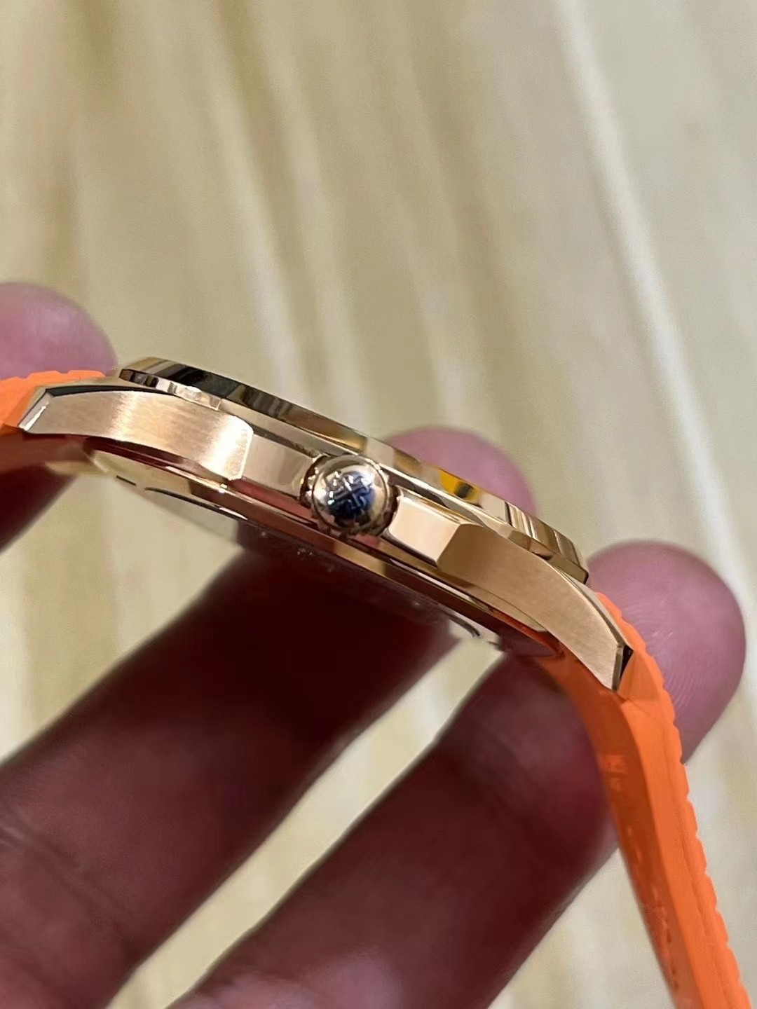 Side profile of Patek Philippe Aquanaut 5167R showing case thickness, crown, and orange strap fit.