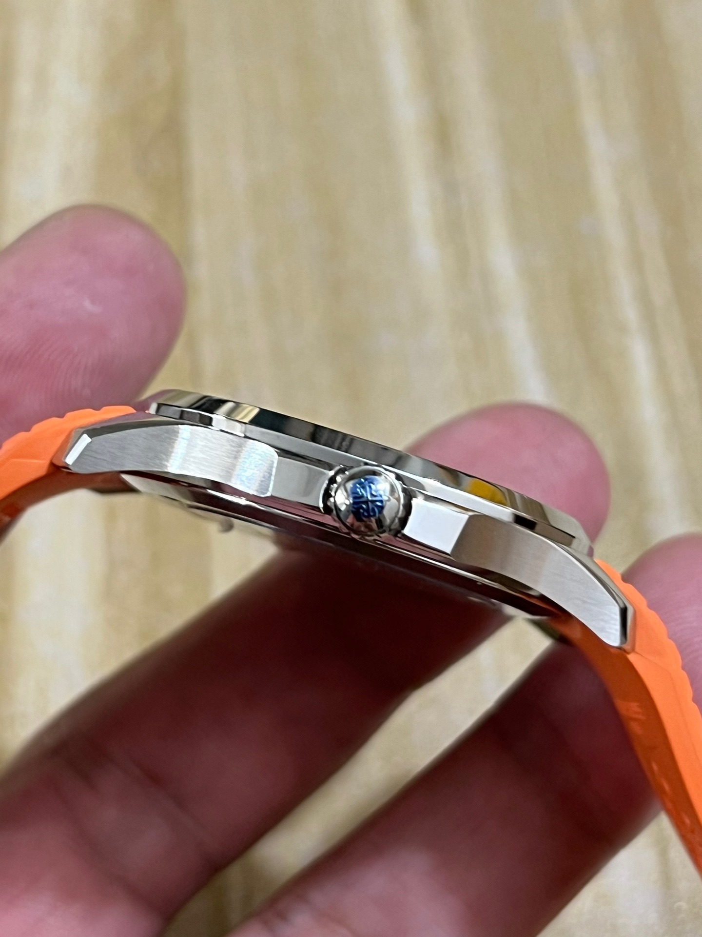 Side angle in hand of Patek Philippe Aquanaut 5167R showing crown side and case finishing.