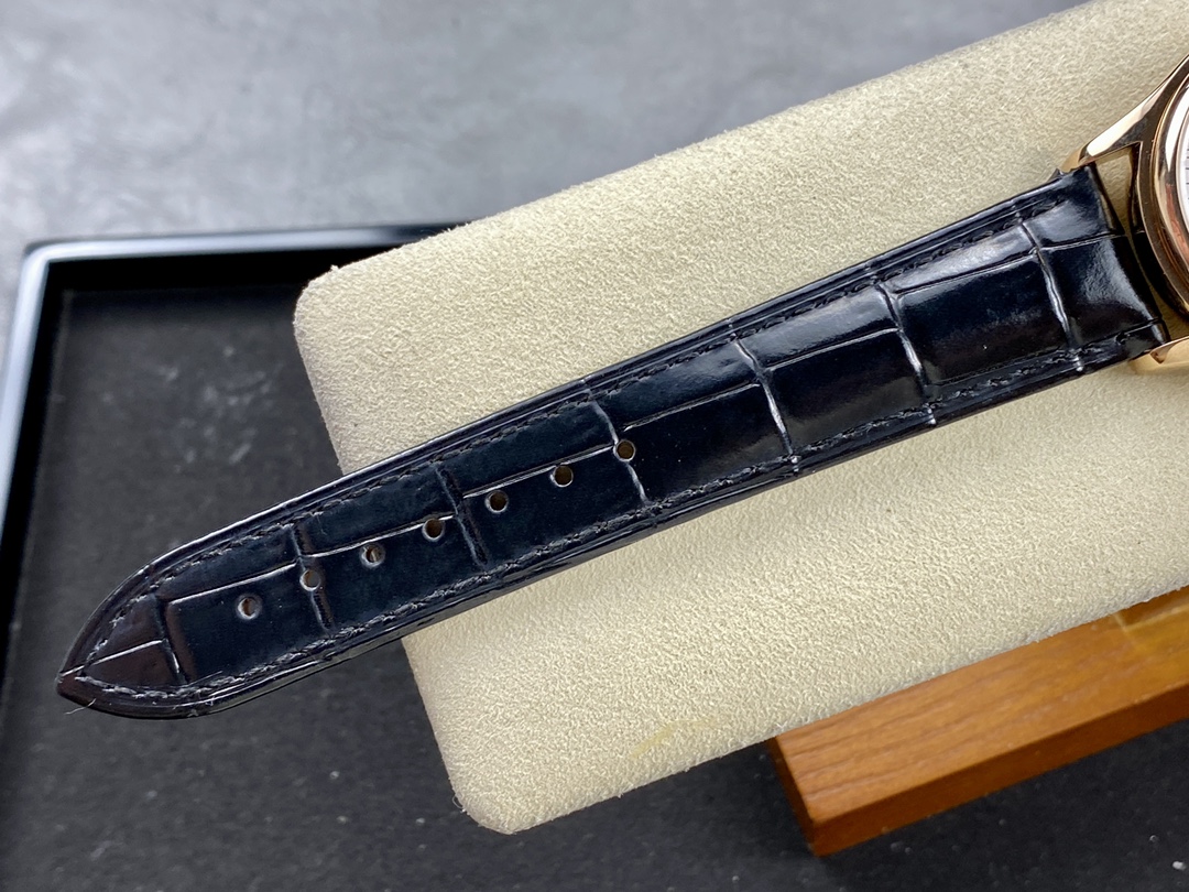 A close-up of the Patek Philippe 5146R-001 with its black strap, placed on a pillow to showcase the details of the leather strap.