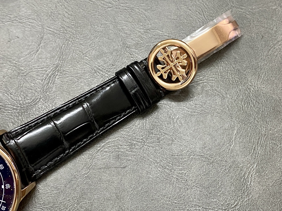 Strap detail of the Patek Philippe 6102P 001 with stitched black leather and clasp emblem.