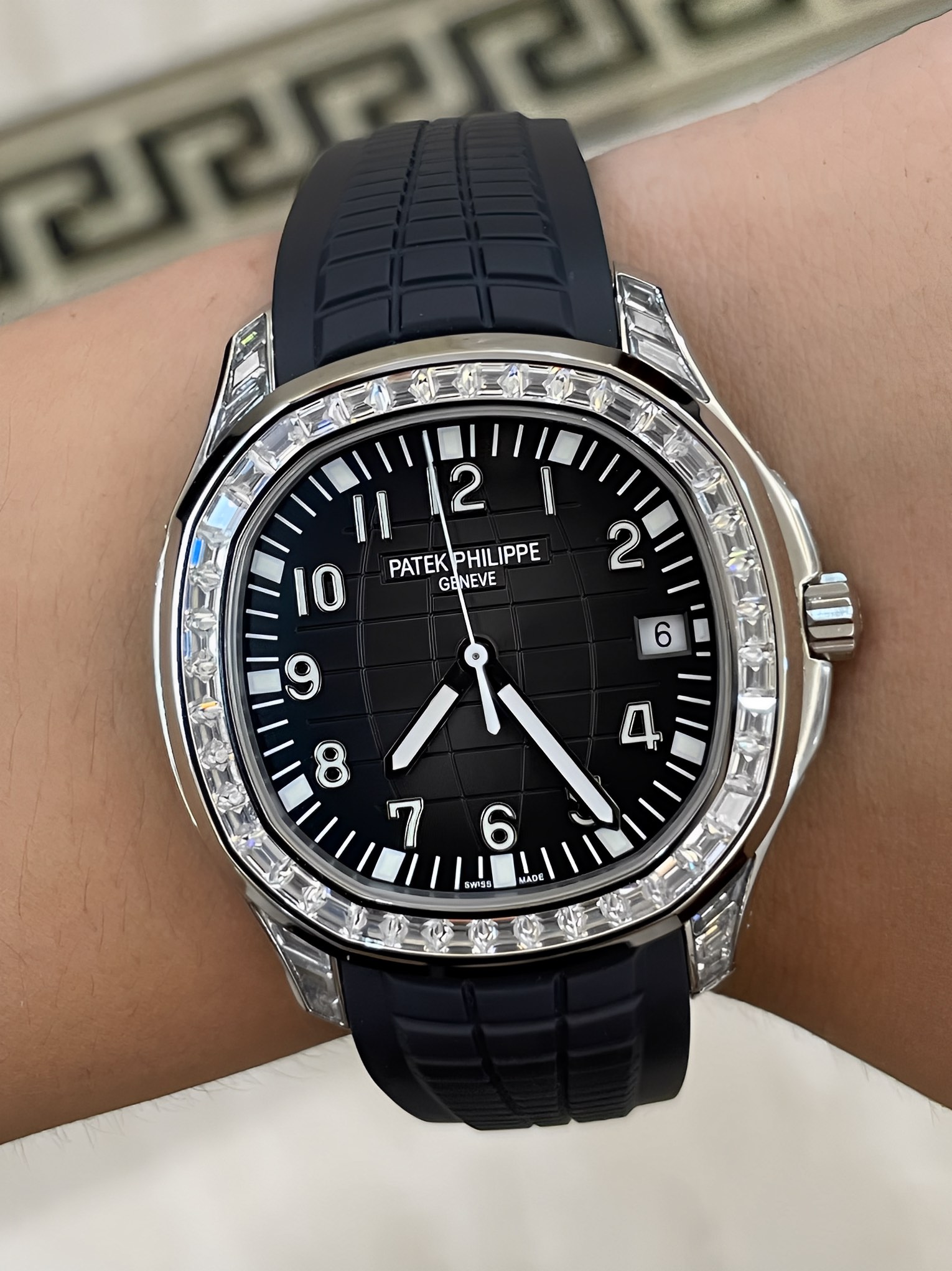 Wrist shot of Patek Philippe Aquanaut 5167/300G-010, black dial with luminous numerals and diamond bezel.