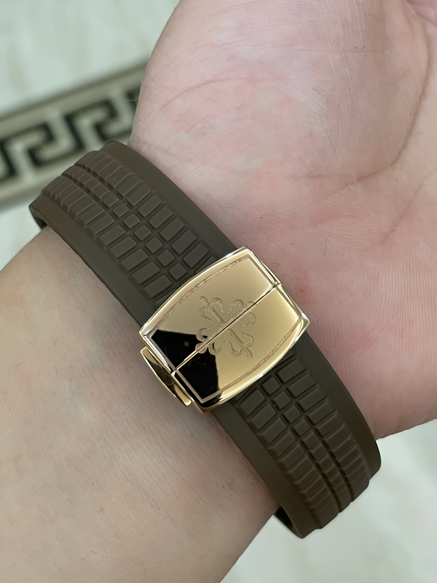 Strap buckle detail of Patek Philippe Aquanaut 5167/300G-010 showing clasp end and brown strap grooves.