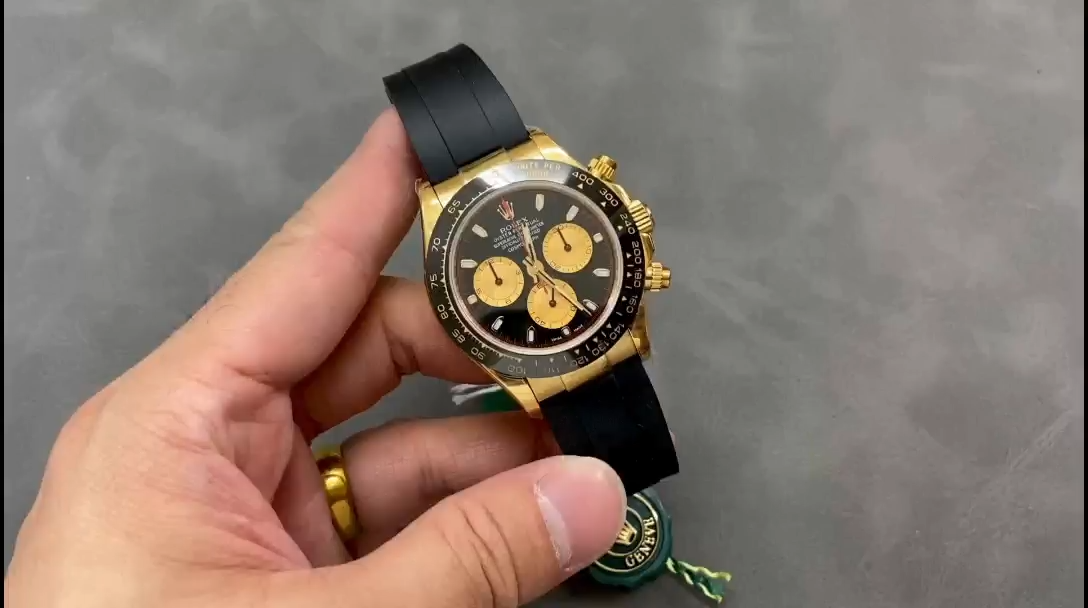 Video: hand holding Rolex Daytona 116518LN, black dial and gold case visible. - Video