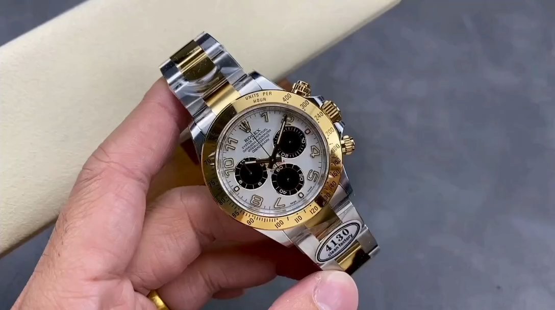 Hand-held video view of the Rolex Daytona 116523 40mm, white Arabic dial and gold bezel visible. - Video