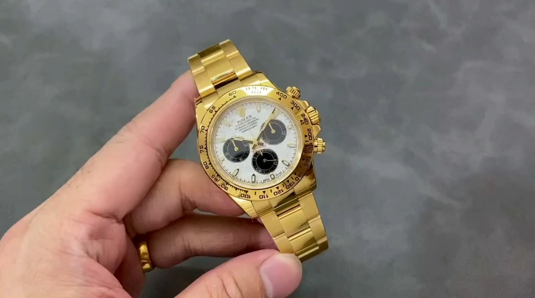 Video: hand holding Rolex Daytona 116508, meteorite grey dial and gold bezel visible. - Video