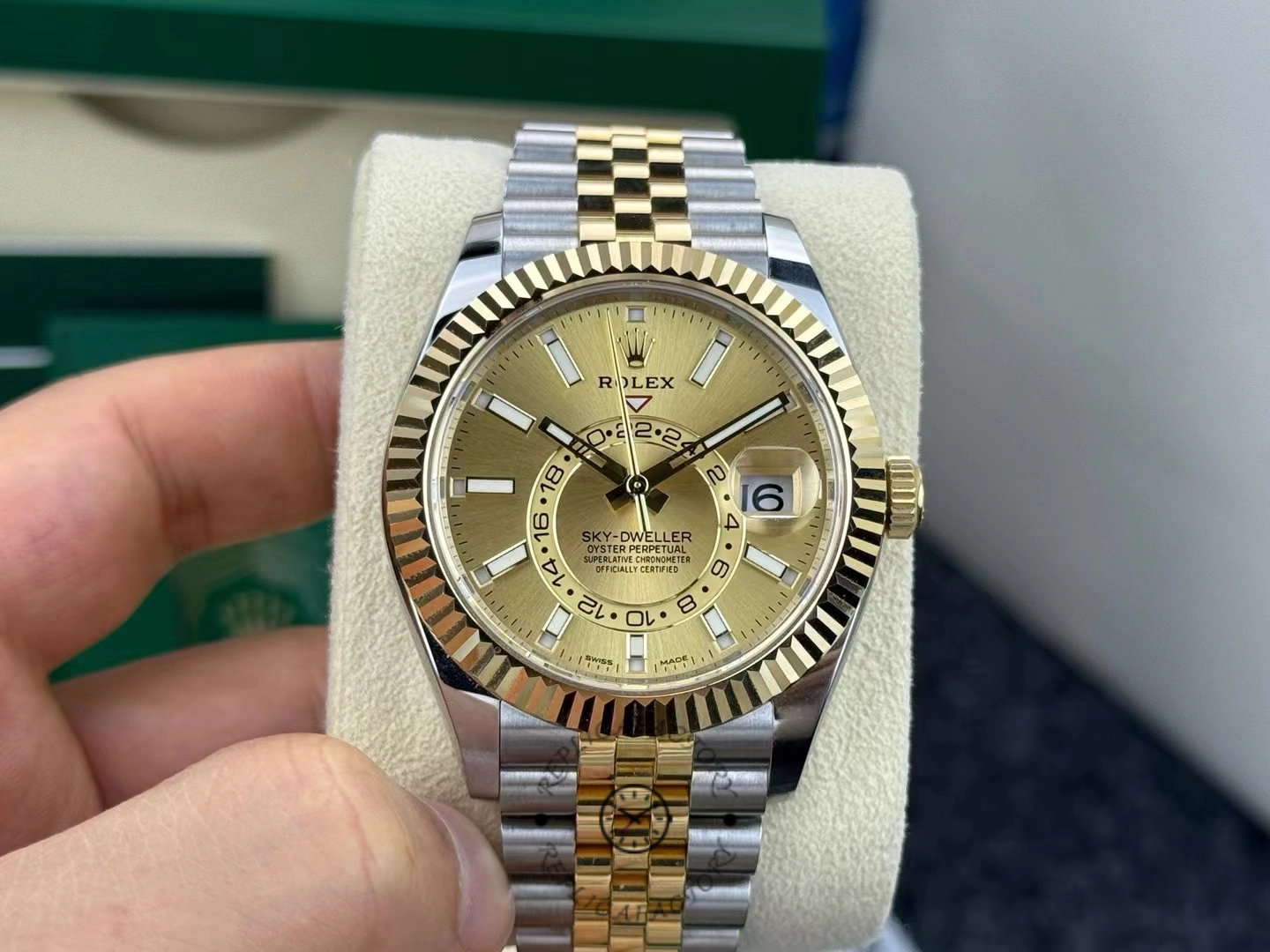 Rolex Sky-Dweller 326933, hand-held front view showing the champagne dial and fluted bezel.