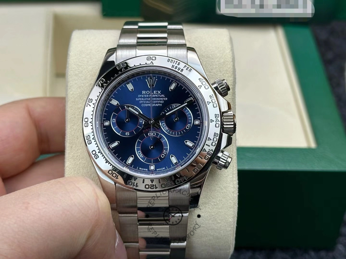 Front view of the Rolex Cosmograph Daytona 116509 40MM with green box background, blue dial shown.